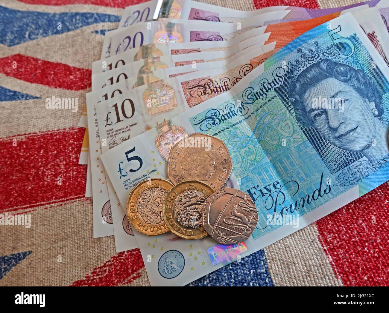 Sterling-Pfund-Scheine, Bank von England und Pfund-Münzen auf einer Gewerkschaft Jack Flagge - Lebenshaltungskosten Krise, in Großbritannien / GB Stockfoto