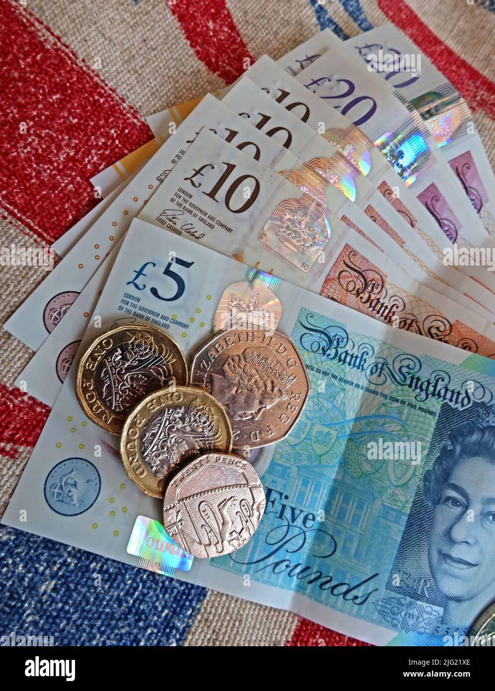 Sterling-Pfund-Scheine, Bank von England und Pfund-Münzen auf einer Gewerkschaft Jack Flagge - Lebenshaltungskosten Krise, in Großbritannien / GB Stockfoto