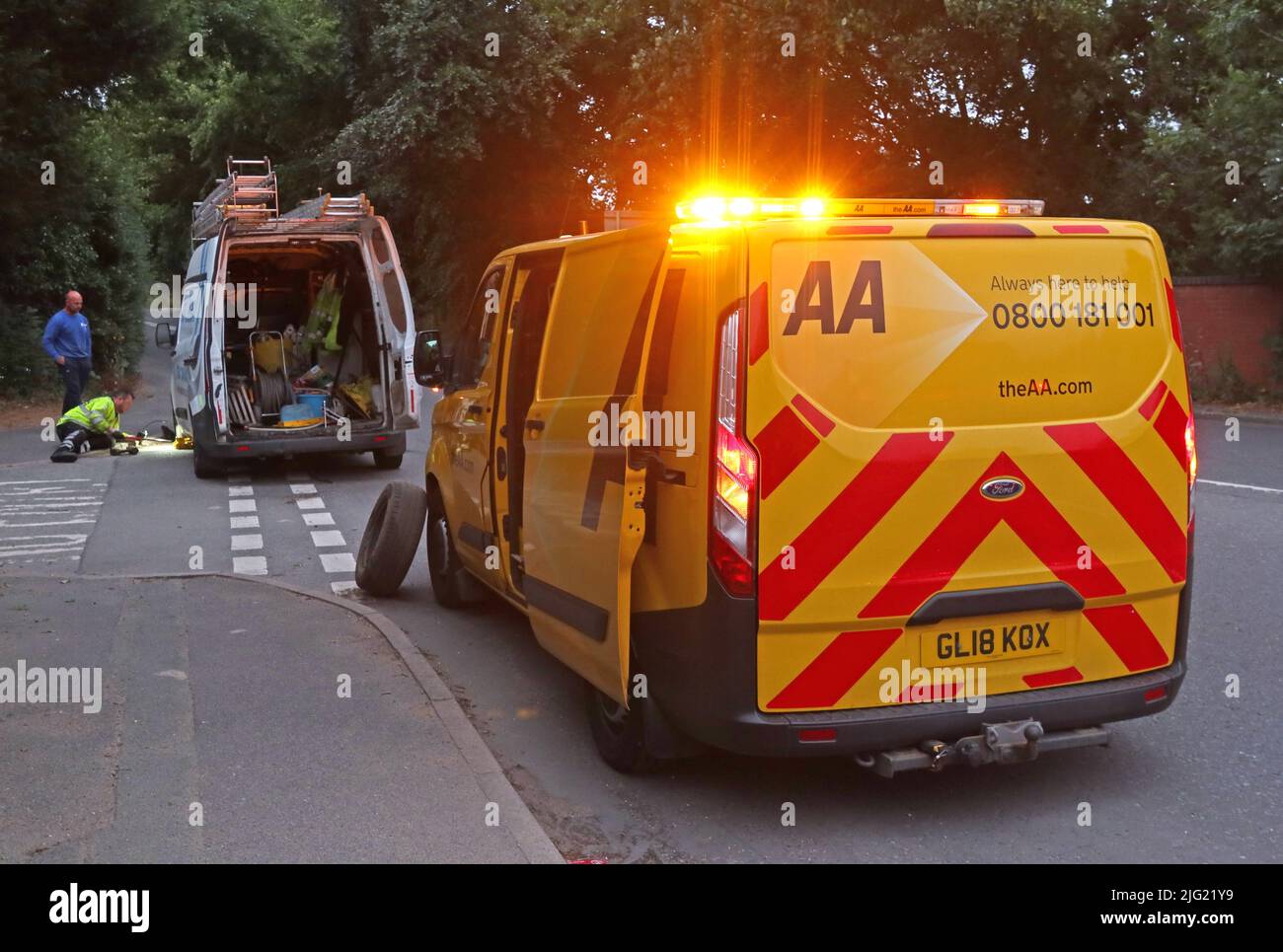 AA van , Automobile Association, Van, der einem gestrandeten Van mit Pannenschaden in der Abenddämmerung zu Hilfe kommt, Grappenhall, Warrington, Ceshire, England, GROSSBRITANNIEN, WA4 Stockfoto