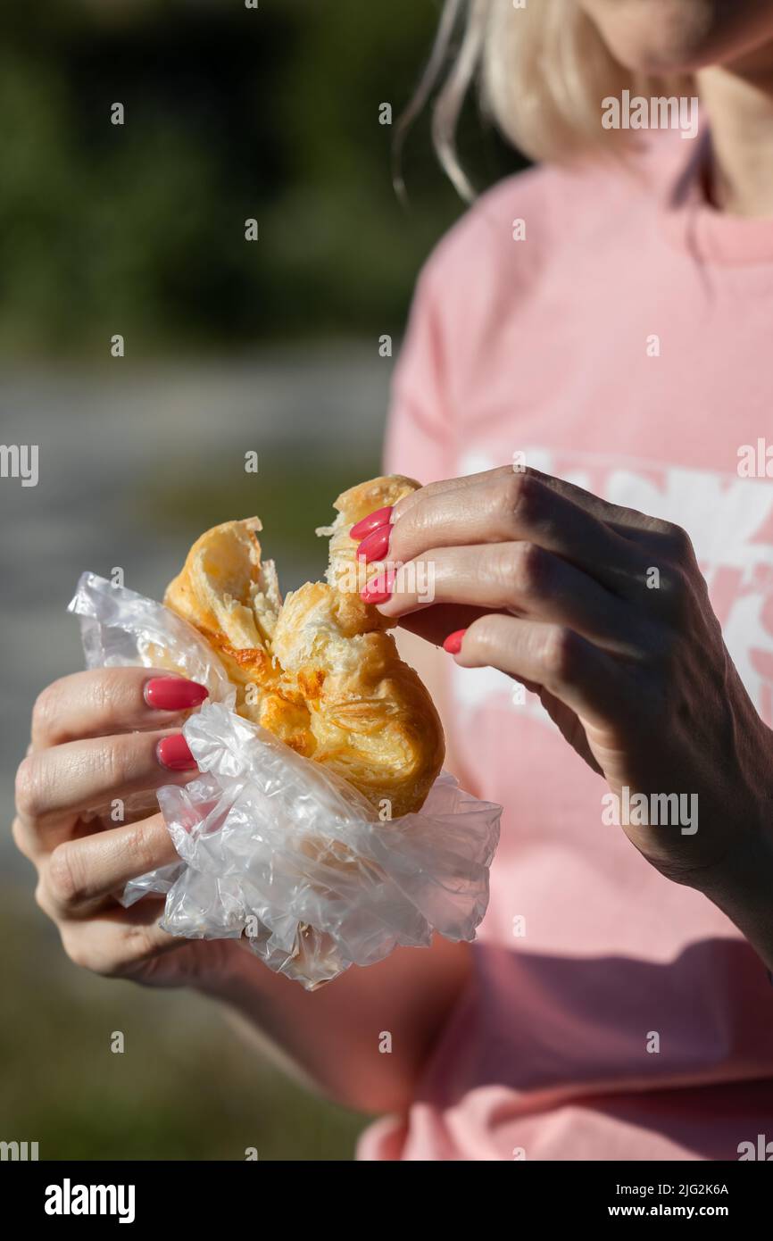 Frau bricht im Park ein Stück Brötchen ab Stockfoto