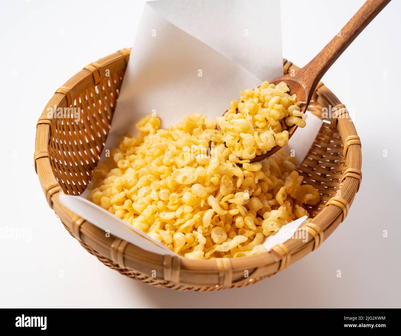 Tempura Dregs serviert in einem Sieb auf weißem Hintergrund mit einem Holzlöffel. Bild von japanischem Essen. Stockfoto