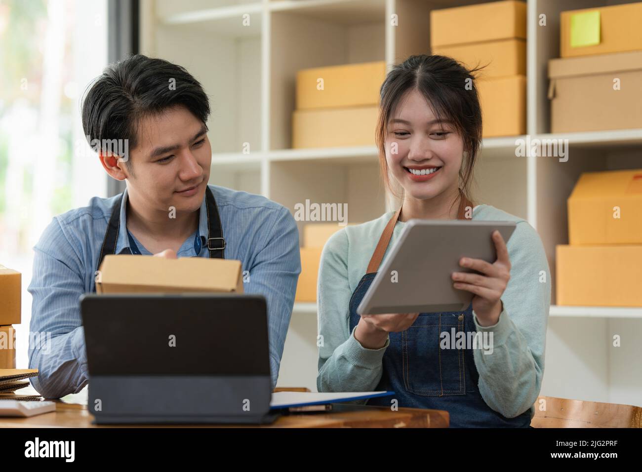 Happy Business Startup Kleinunternehmen mit Paketkasten für die Lieferung an Kunden und die Zusammenarbeit zu Hause. Stockfoto