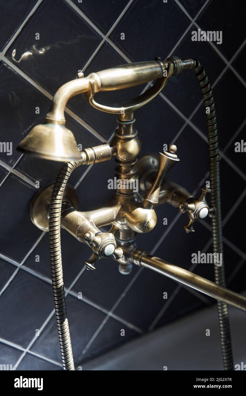 Gold Wasserhahn und Dusche alten Vintage-Stil mit grauen Fliesen Hintergrund Stockfoto