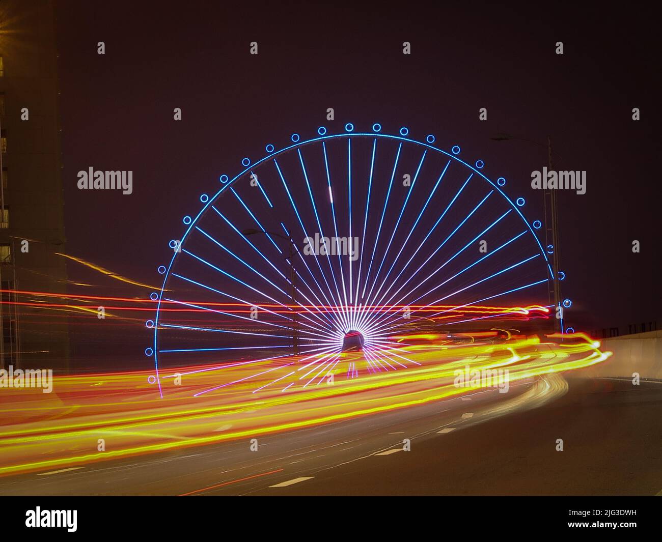 Ain Dubai bei Nacht mit leichten Wegen von Autos Stockfoto