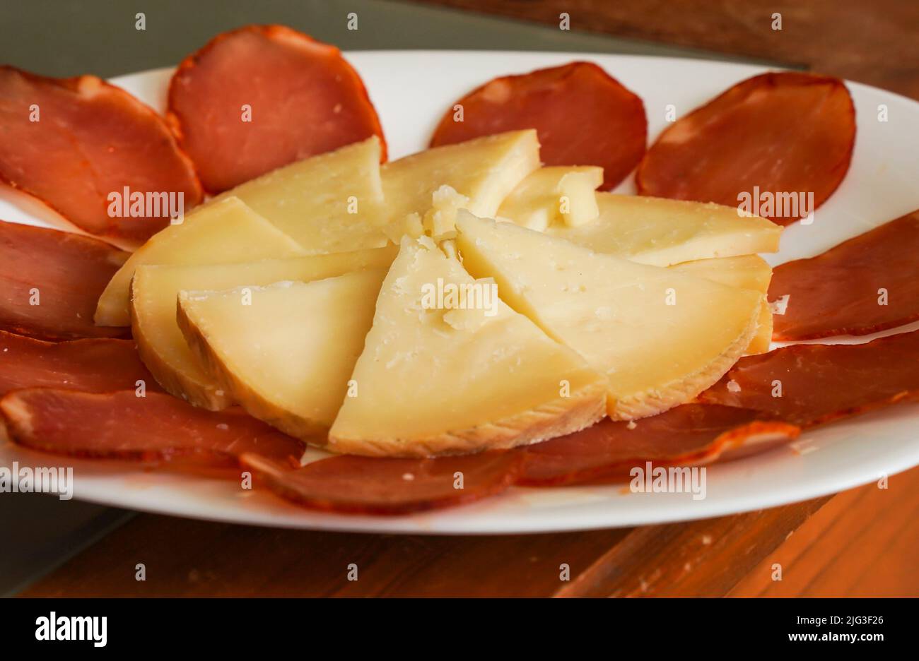Manchego-Käse auf einem Bett aus Lomo, trockengeräucherter Wurst. Stockfoto