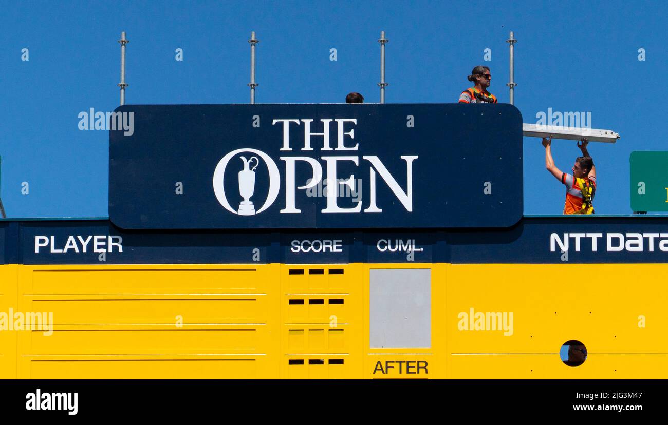 St Andrews, Schottland, Großbritannien. 7. Juli 2022. Der Old Course in St Andrews ist ein voller Aktivitäten, eine Woche vor der ersten Runde der Open Championship 150.. Mitglieder der Öffentlichkeit dürfen auf den Fairways spazieren gehen, da der Old Course ein öffentlicher Park ist. Touristen haben diesen Zugang genutzt, um neben berühmten Sehenswürdigkeiten wie der Svilken Burn-Brücke auf dem 18.-Loch-Loch-Platz für Fotos zu posieren. PIC; Arbeiter errichten berühmte gelbe Anzeigetafel neben 18. grün. Iain Masterton/Alamy Live News Stockfoto