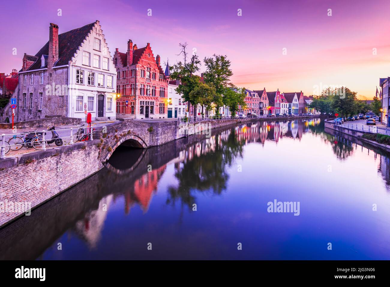 Brügge, Belgien. Blue Hour Sunrise Landschaft mit Wasserspiegelungen Häuser am Spiegelrei Kanal, berühmtes Wahrzeichen Flanders. Stockfoto