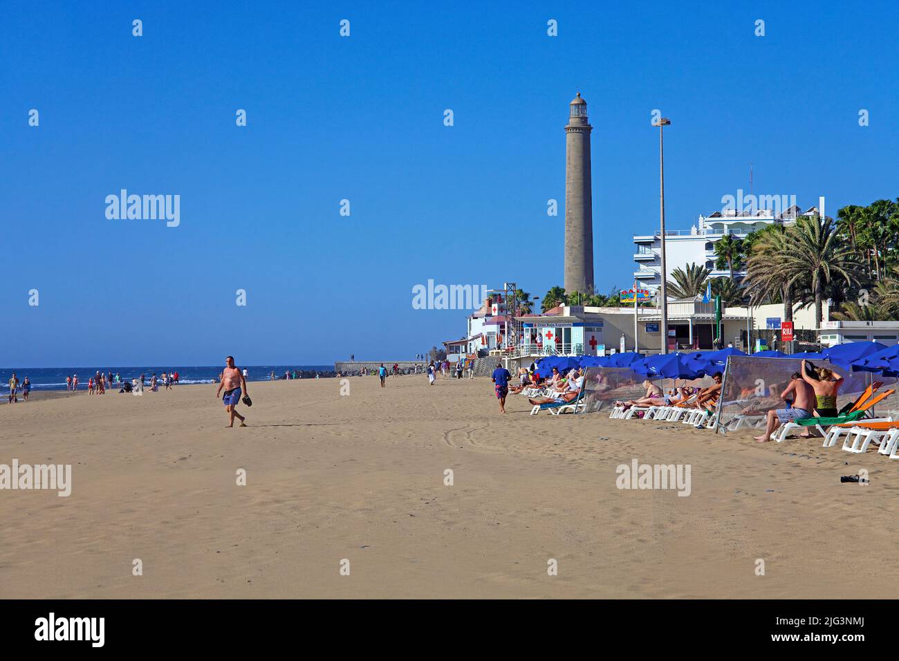 Touristen am Strand, hinter dem Leuchtturm von Maspalomas, Grand Canary, Kanarische Inseln, Spanien, Europa Stockfoto