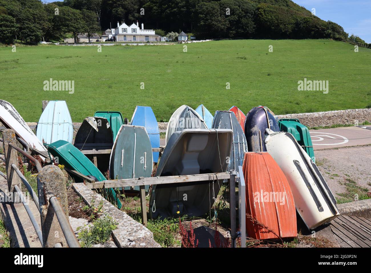 AXMOUTH, DEVON, ENGLAND - JULI 12. 2020: Umgedrehte Ruderboote am Ufer der Axe in Axmouth Stockfoto