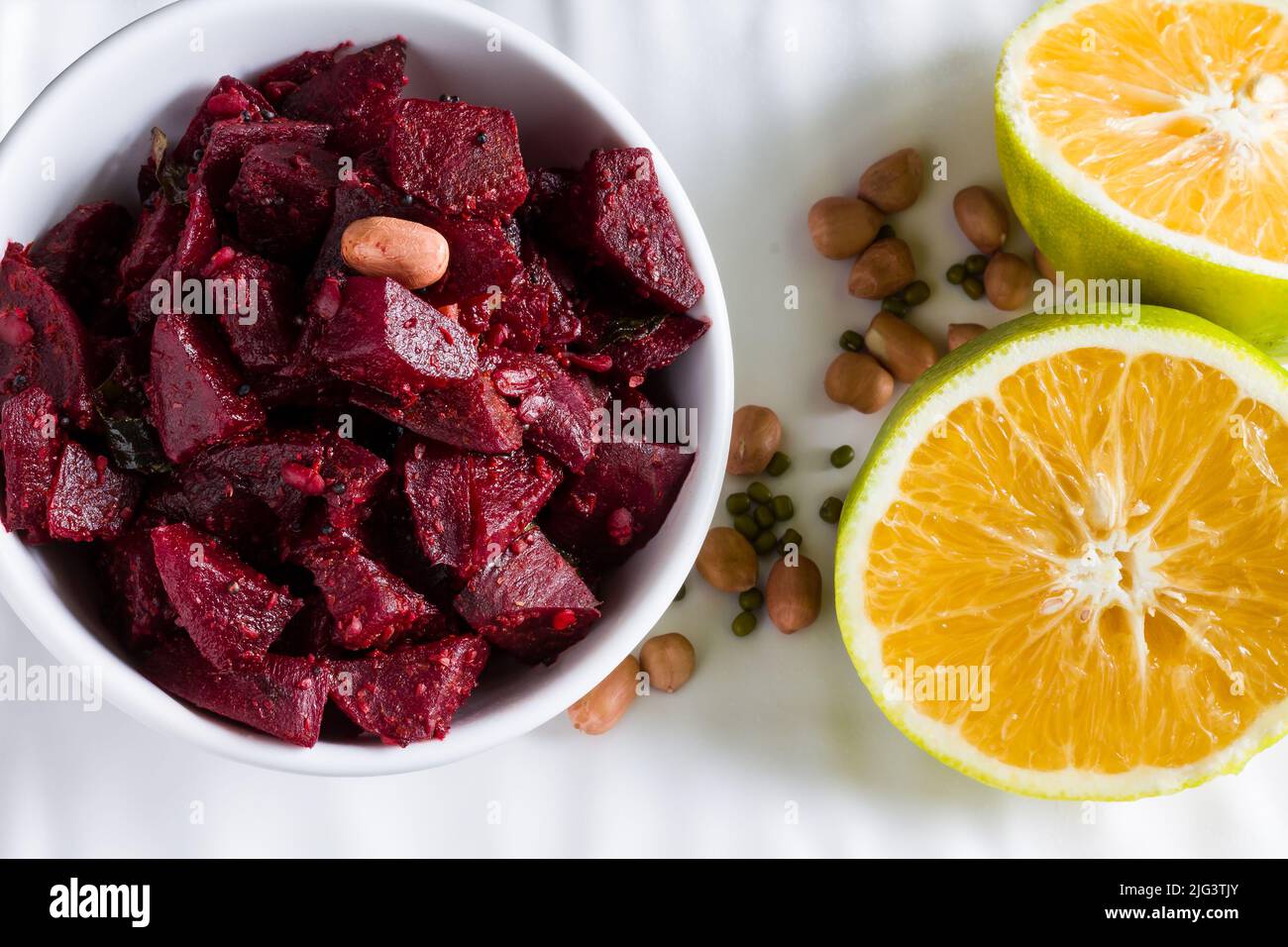 Selektiver Fokus auf sautierten oder Braten Rote Beete Gemüse, garniert mit Erdnüssen, Minze, süße Limette. Gesundes Essen Konzept der südindischen Beilage. Stockfoto