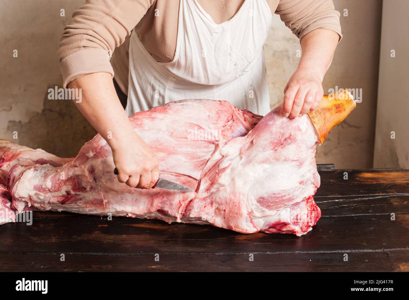 Metzger schnitzen rohes Schweinefleisch auf dem lokalen Markt Stockfoto