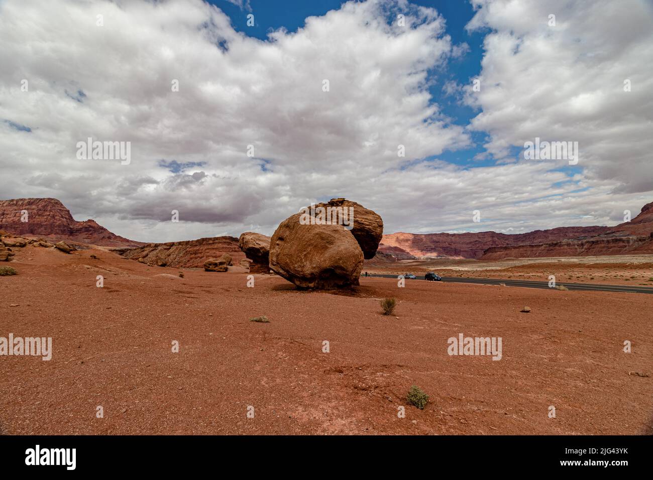 Autos erscheinen winzig vor so riesigen Kalksteinfelsen, Vermillion Cliff Range, Page, AZ, USA Stockfoto