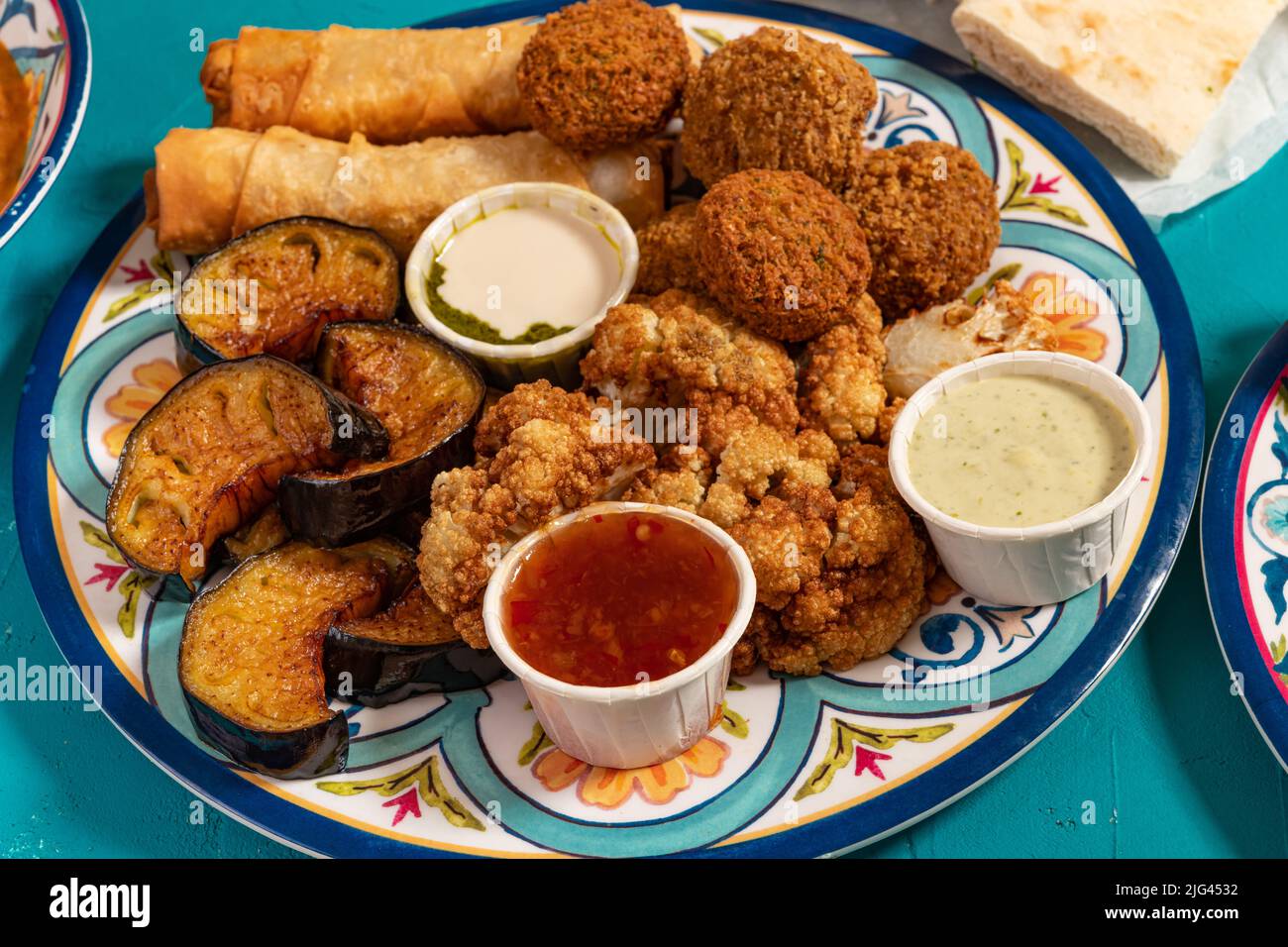 Traditionelles mediterranes arabisches warmes Frühstück mit gebratenem Blumenkohl, Auberginen, Falafel, Käserollen und verschiedenen Dips Stockfoto