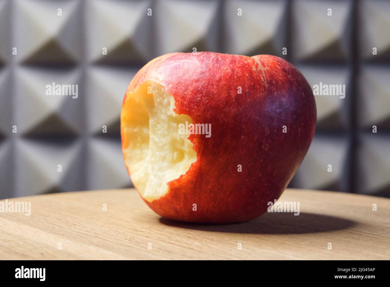 Ein gebissenen roten Apfel auf einer hölzernen Oberfläche. Stockfoto