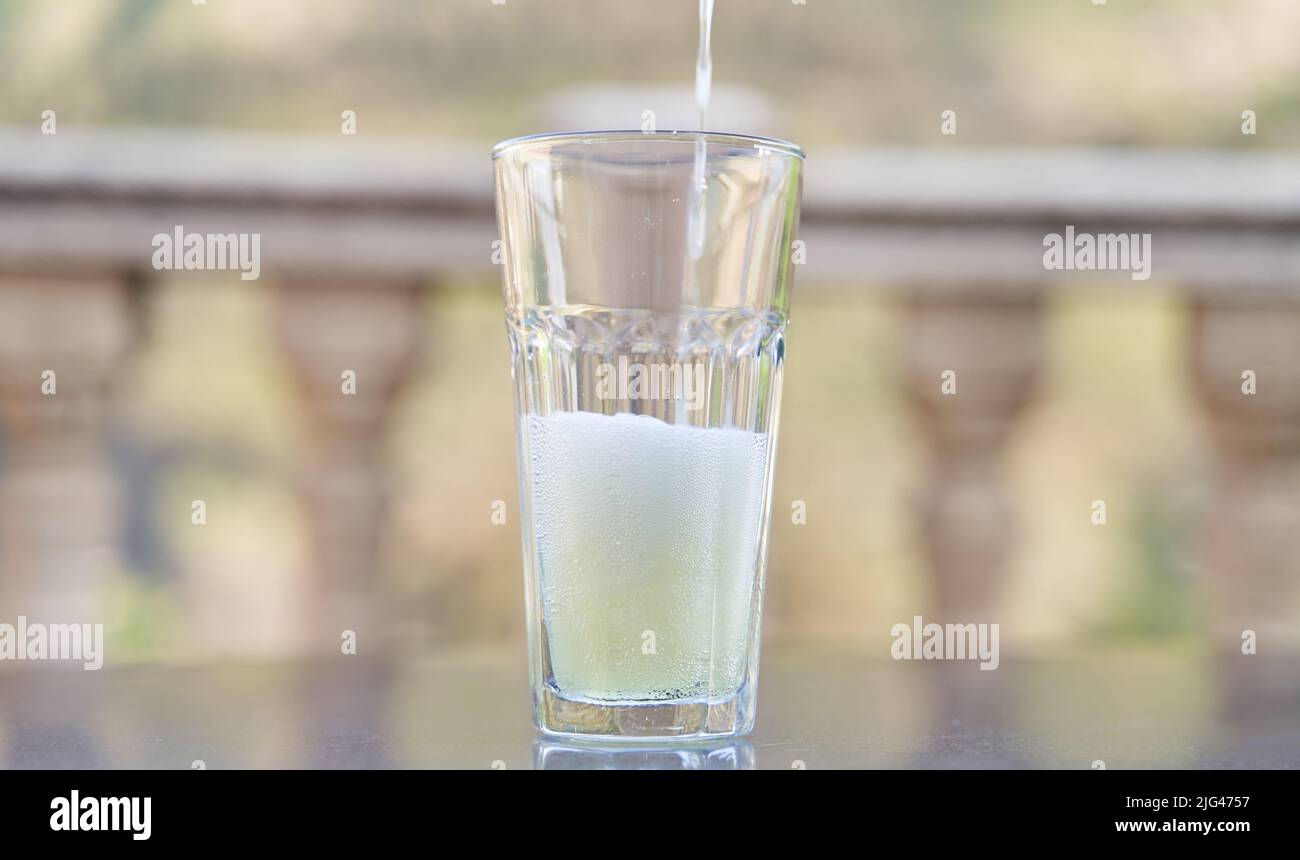Limonade in Glas gießen. Erfrischendes Getränk im Sommer Stockfoto