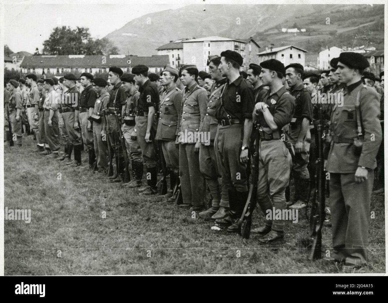 [Ein Moment der Parade der nationalen Truppen in Tolosa, 1939]. Parade der nationalen Truppen in San Sebastian und Tolosa: Regelmäßige Militär und andere werden mit Carlist Barets, sowie Falangisten beobachtet Stockfoto