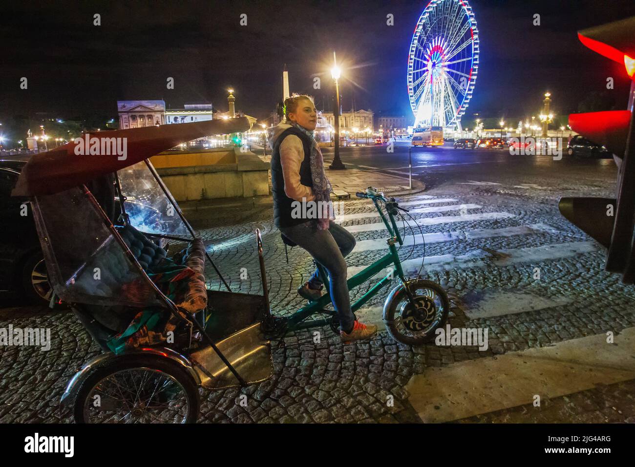 14-05-2016 PARIS, Frankreich. Eine junge Frau - eine Rikscha, von europäischem Aussehen, und ein Riesenrad in der Nacht und Pflastersteine und Place de la Concor Stockfoto