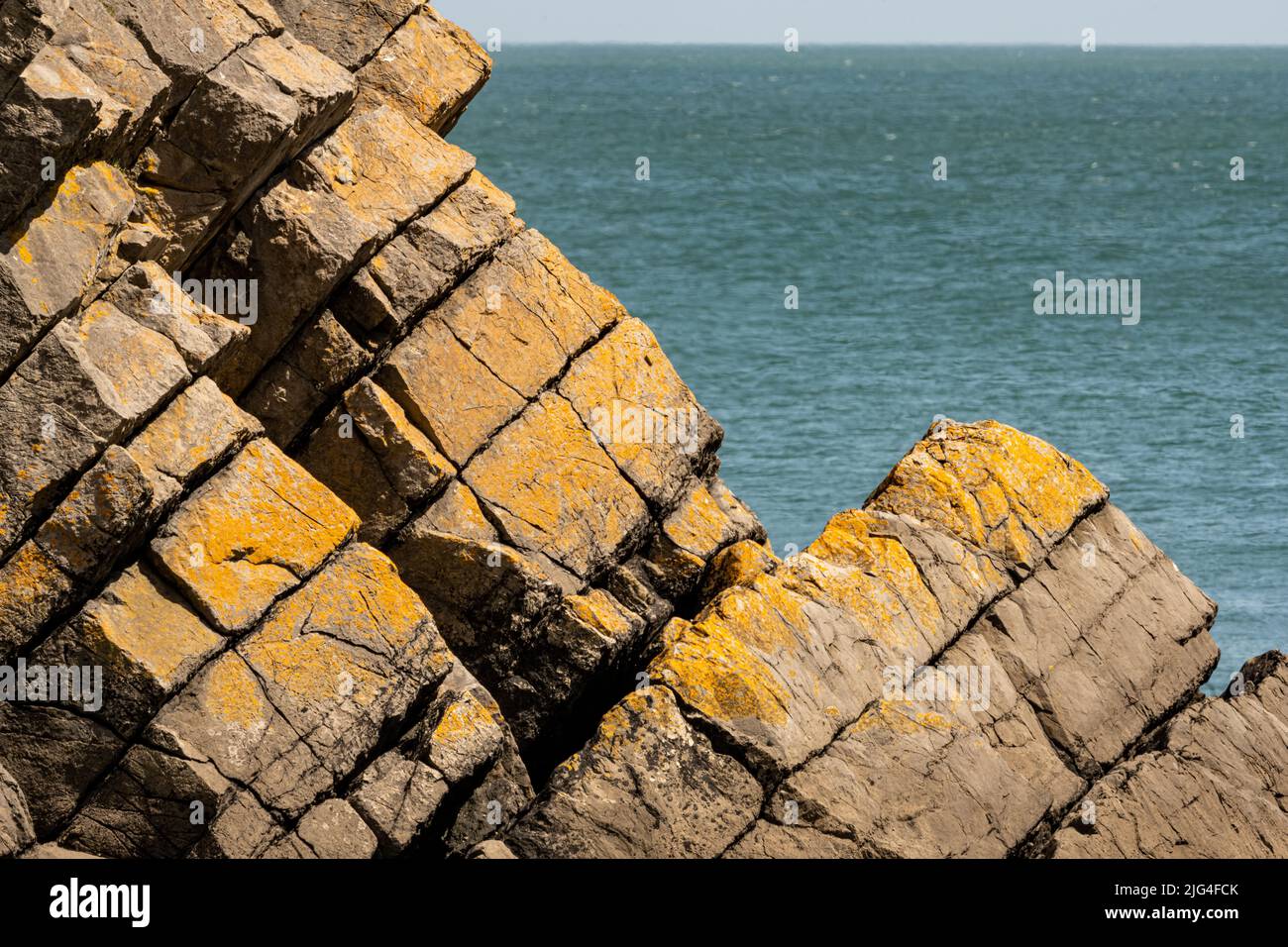 Geschichtete und farbige Felsformationen am Stackpole Quay, einem kleinen Hafen, der vom National Trust in Pembrokeshire, Wales, Großbritannien, verwaltet wird Stockfoto