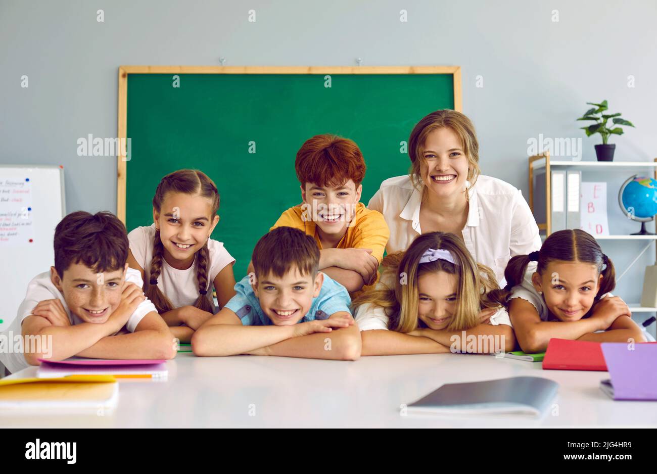Porträt einer fröhlichen Gruppe von Grundschülerinnen und ihrer freundlichen, beiläufigen Lehrerin. Stockfoto