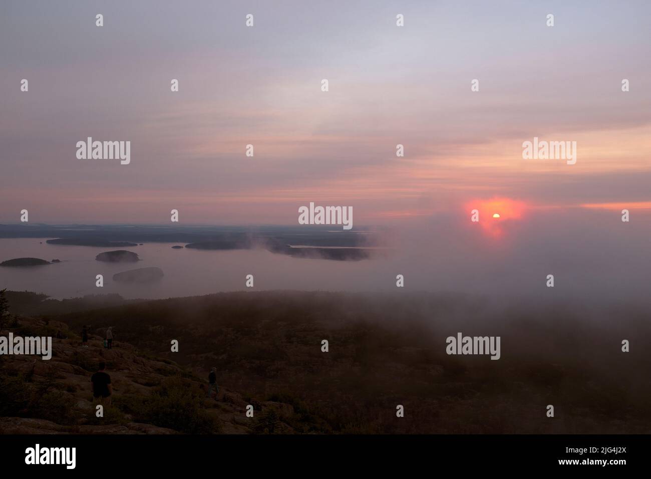 Eine Gruppe von Menschen versammelten sich, um den Sonnenaufgang vom Cadillac Mountain, Maine, USA, aus zu beobachten Stockfoto