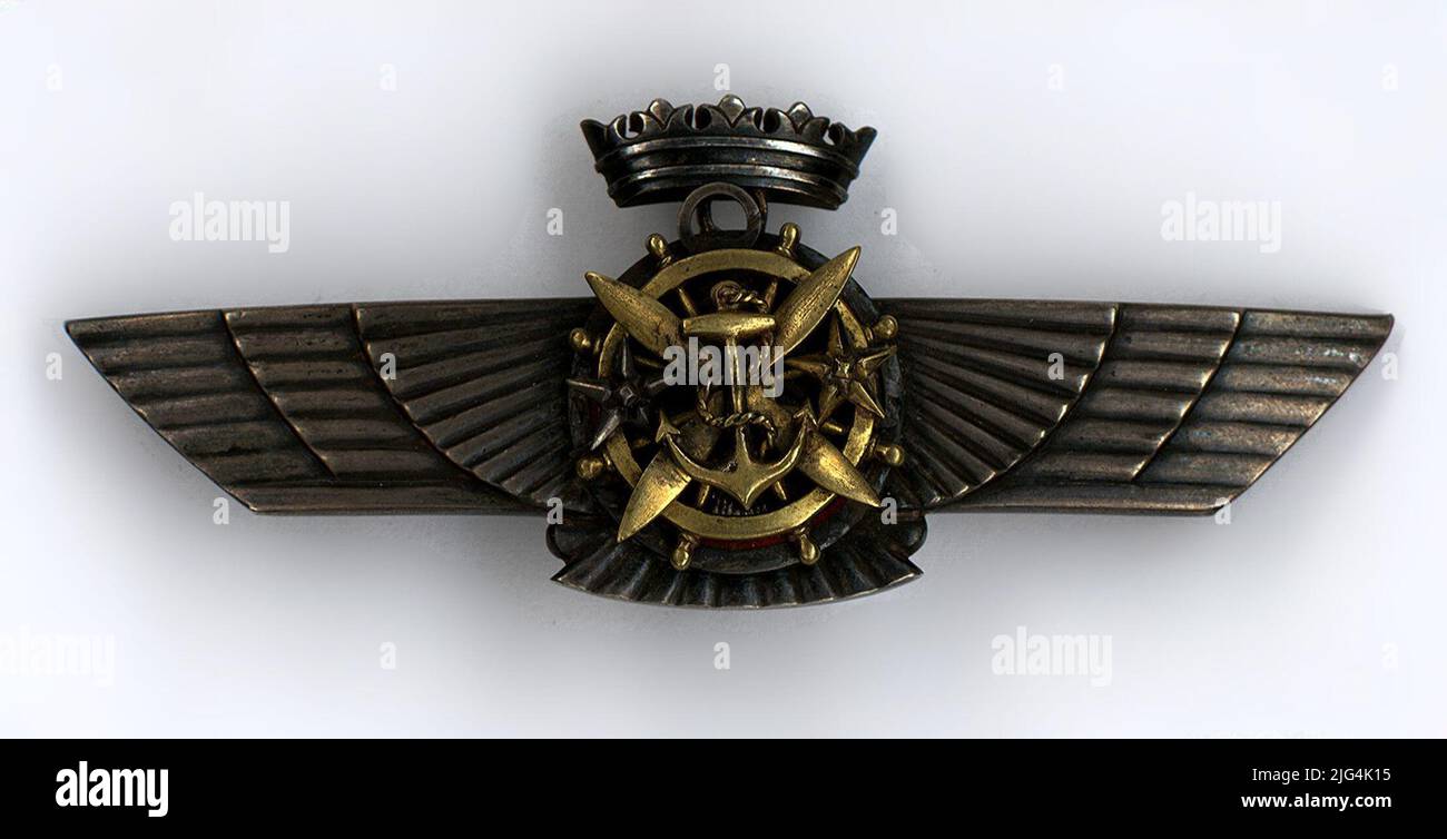 Unterscheidungskraft von General Alfredo Kindelán Duany. Pilotenabzeichen. Im oberen Teil hat sie eine kaiserliche Krone. Auf dem mittleren Kreis, rot emailliert, erscheint der Adler von San Juan. Auf ihm sind der markante Titel des Luftschiffpiloten (ein goldenes Ruder), des Flugzeugpiloten (vier Klingen, Gold), des Globenpiloten (ein goldener Anker), des Flugzeugbeobachters (fünfzackig goldener Stern) und des Beobachters Aerosttero (fünfzackig silberner Stern) zu sehen. Auf der Rückseite die Zahl 1. Im oberen Rand des rechten Flügels befindet sich der Kontrast der Juwelierinschriften - Transkription: 1. Registrierung - Standort: Zurück Stockfoto