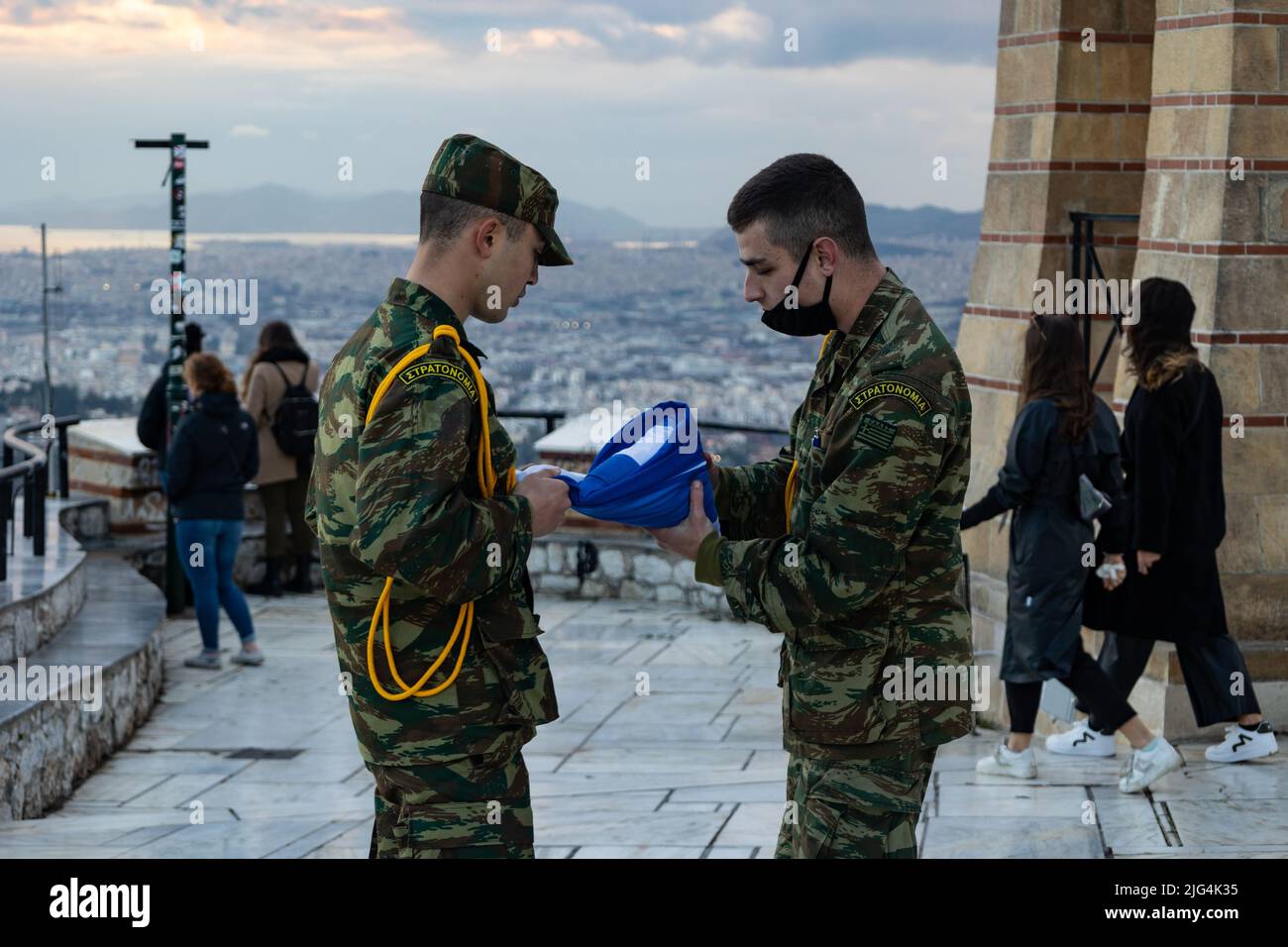 Zwei Soldaten senken und falten die griechische Flagge am Berg Lycabettus Stockfoto