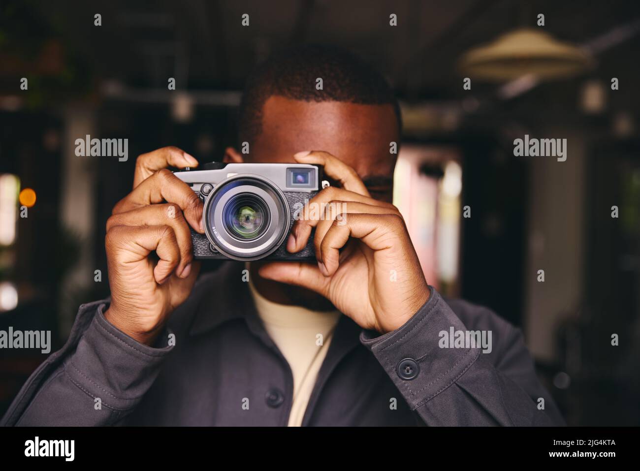 Fotograf, der ein Bild mit der Kamera durch das Objektiv schaut Stockfoto