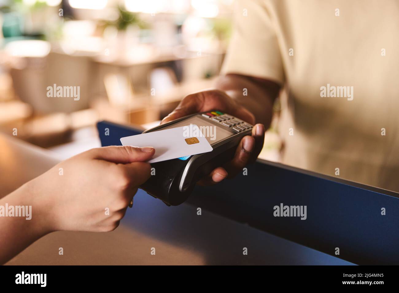 Schließen Sie den Verkaufsassistenten im Einzelhandelsgeschäft mit Kundenzahlung über kontaktlose Zahlung per Kreditkarte NFC ab Stockfoto
