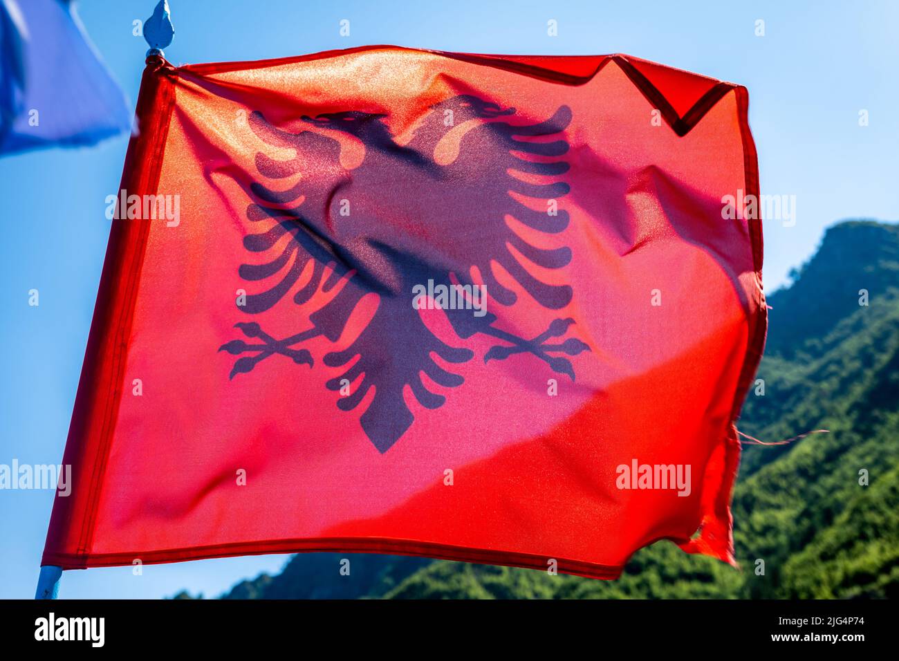 Albanien Flagge vor Himmel Hintergrund. Nahaufnahme der schwenkenden Flagge Albaniens, offiziell der Republik Albanien. Stockfoto