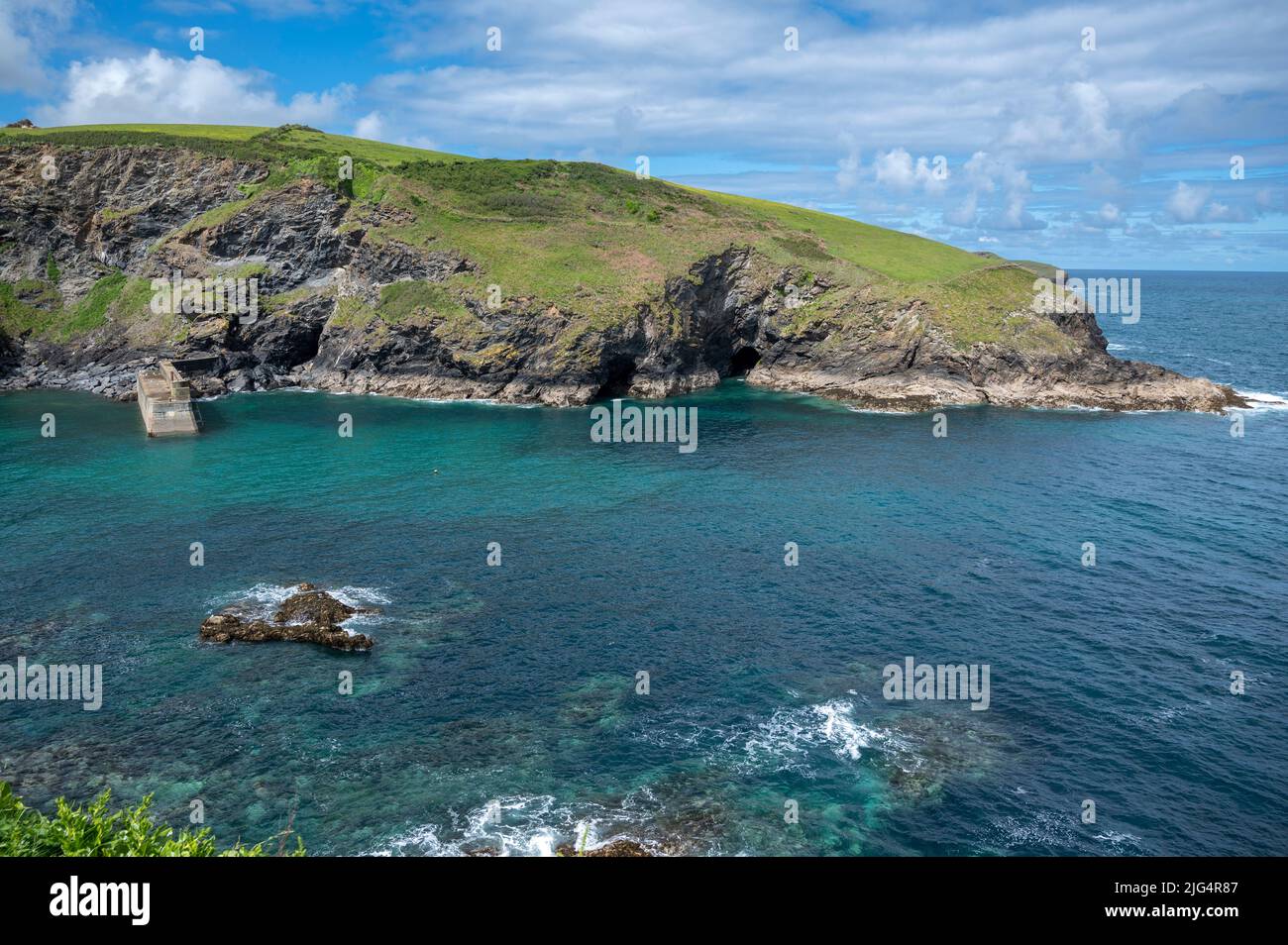 Die Klippen und das klare blaue Wasser rund um den Hafeneingang des hübschen Küstendorfes Port Isaac, Cornwall. VEREINIGTES KÖNIGREICH. Stockfoto