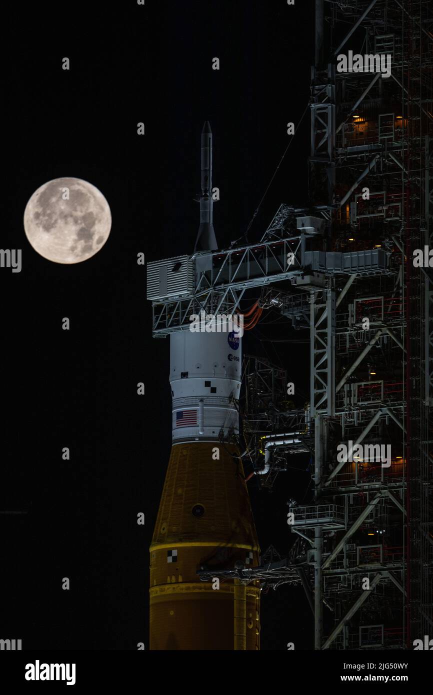 Am 14. Juni 2022 im Kennedy Space Center in Cape Canaveral, Florida, erhebt sich ein Vollmond über der NASA-Rakete Artemis I Space Launch System mit der Raumsonde Orion an Bord eines mobilen Trägerraketen im Launch Complex 39B. Der SLS und Orion werden für eine Generalprobe vorbereitet, um Zeitpläne und Verfahren für die Einführung zu üben. Stockfoto