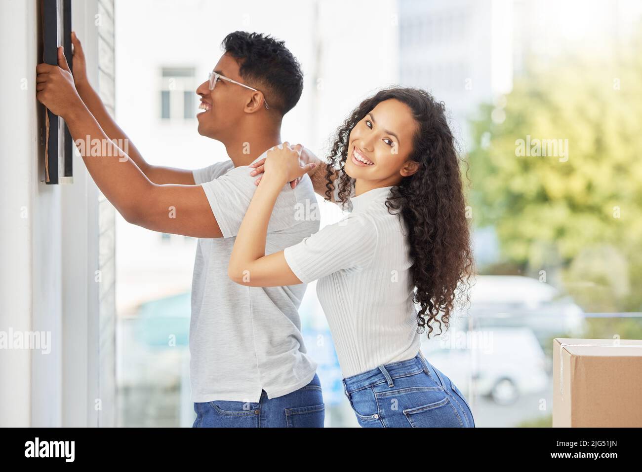 Setzen Sie uns in einen Rahmen, weil das Bild perfekt waren. Aufnahme eines jungen Paares, das sein neues Haus schmückt. Stockfoto