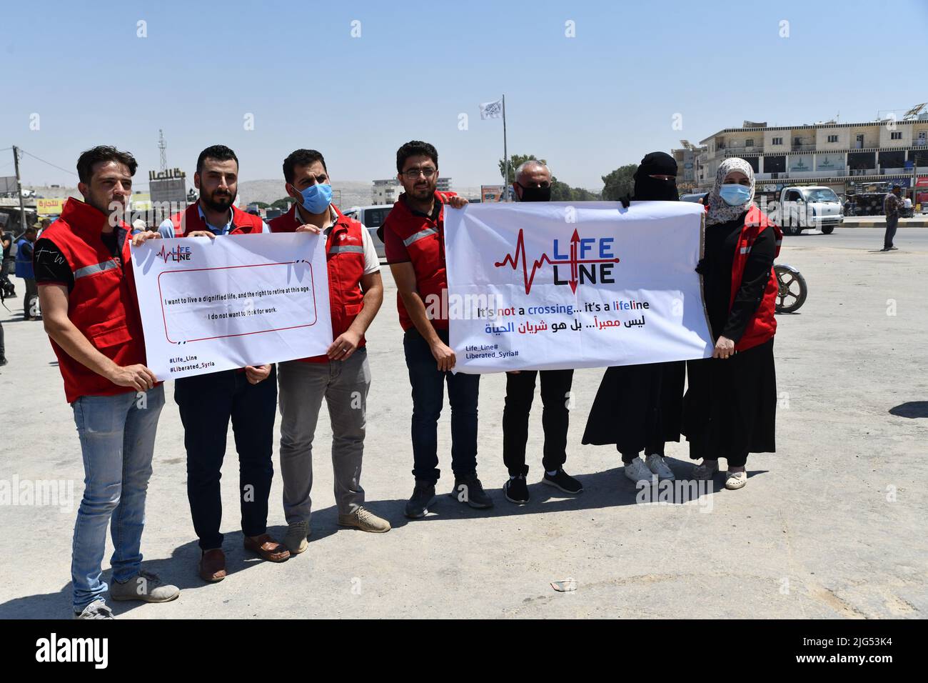 Sarmada, Idlib, Syrien, 7. Juli 2022 ، in der Nähe der Stadt Sarmada im von Rebellen gehaltenen Teil der nordwestlichen Provinz Idlib in Syrien versammeln sich am 7. Juli 2022 humanitäre Helfer, um gegen jede erwartete Schließung des Grenzübergangs Bab al-Hawa mit der Türkei zu demonstrieren und humanitäre Hilfe zu leisten Stockfoto