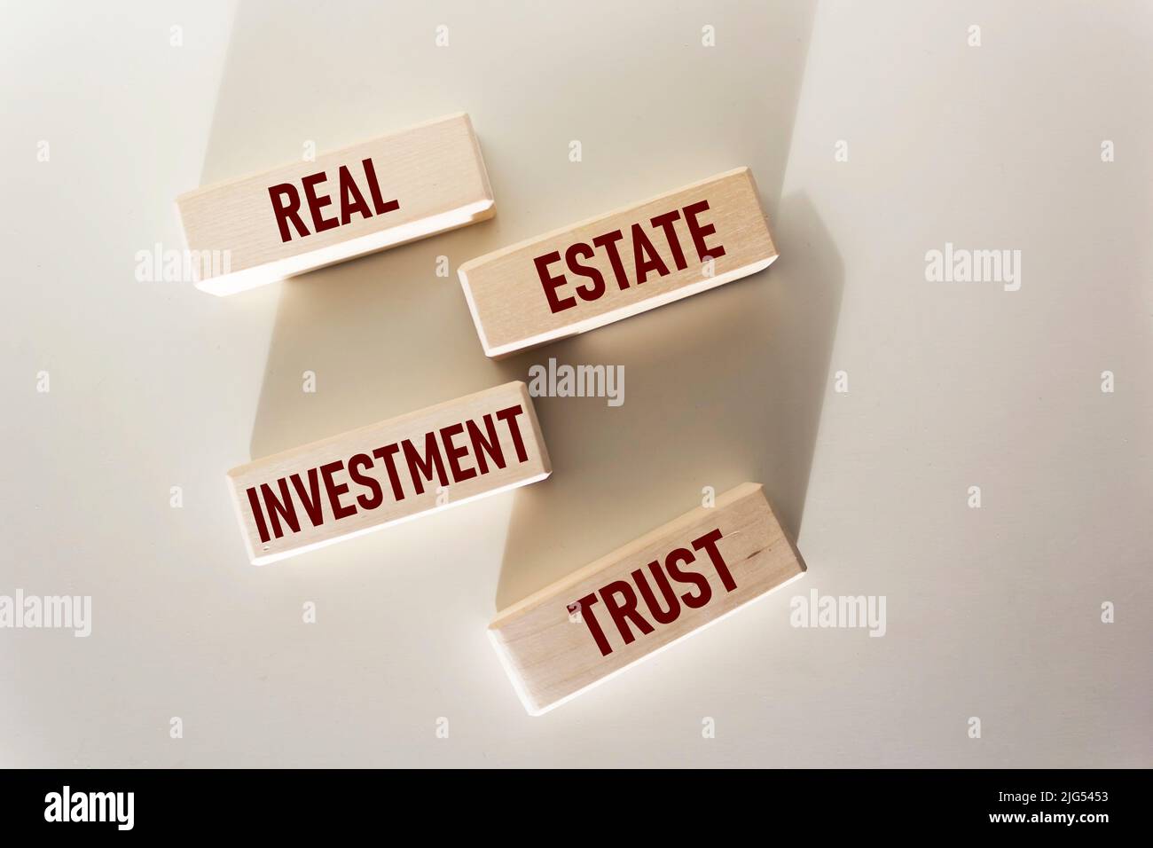 REIT-Investmentfondssymbol. Konzeptionelle Worte REIT Real Estate Investment Fund auf Holzblöcken auf weißem Hintergrund. Immobilien Investment Trust RE Stockfoto