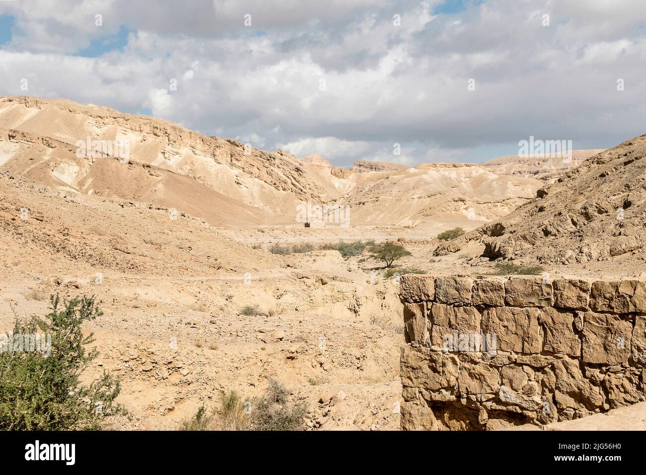 Uralte, oberirdische Nabatäische Zisterne an der Gewürzstraße im Negev in Israel mit der Festung Metsad Nekarot im Hintergrund unter wolkenfreiem Himmel Stockfoto