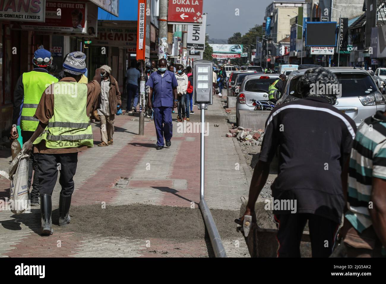 Nakuru, Kenia. 7.. Juli 2022. Arbeiter werden dabei gesehen, wie sie sich darauf vorbereiten, eine solarbetriebene Straßenleuchte auf der Kenyatta Avenue im zentralen Geschäftsviertel zu installieren. Die Regierung von Nakuru County mit Unterstützung der Weltbank installiert Solar-Straßenlaternen, um die Sicherheit der Stadt zu verbessern. Die solare Straßenbeleuchtung ist umweltfreundlich, sie nutzt erneuerbare Energie aus der Sonne und trägt daher nur wenig CO2-Emissionen bei, die für den Klimawandel verantwortlich sind. (Bild: © James Wakibia/SOPA Images via ZUMA Press Wire) Stockfoto