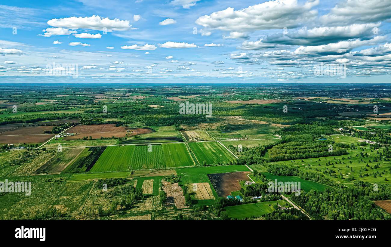 Ein wunderschöner Himmel schwebt über einem unterentwickelten Gebiet von Wisconsin. Farm landet um die Wälder mit neuen Häusern. Eine schöne Aussicht auf jeden Fall! Stockfoto