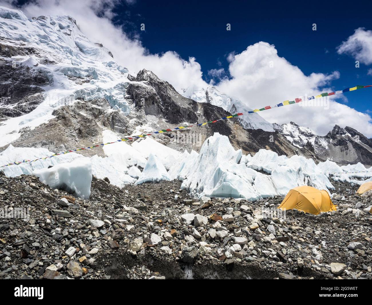 Gelbe Zelte des Everest-Basislagers in der Nähe von kleinen Seracs am Khumbu-Eisbruch. Stockfoto