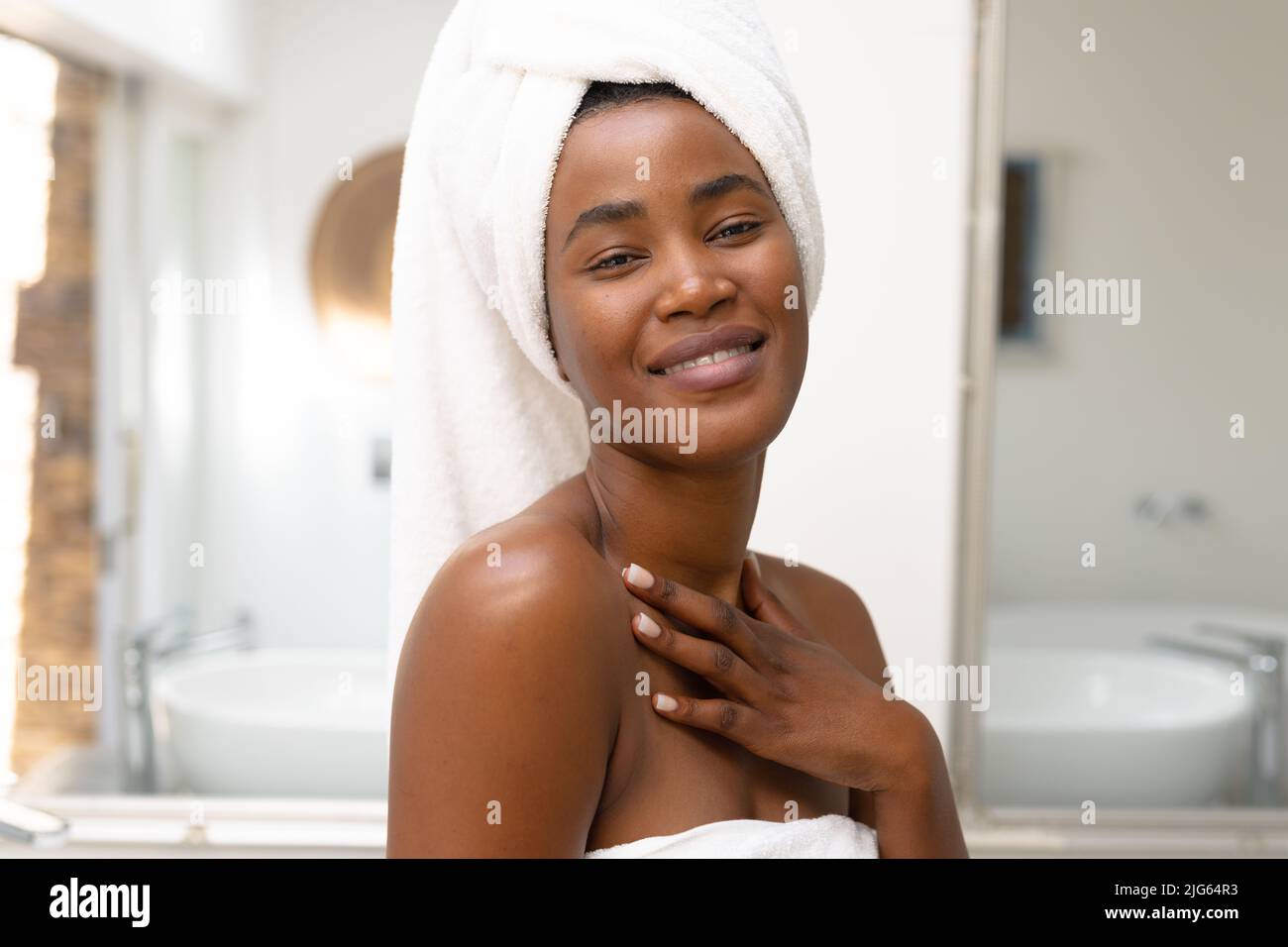 Porträt einer selbstbewussten afroamerikanischen jungen Frau, die im Badezimmer zu Hause lächelt, Platz kopieren Stockfoto