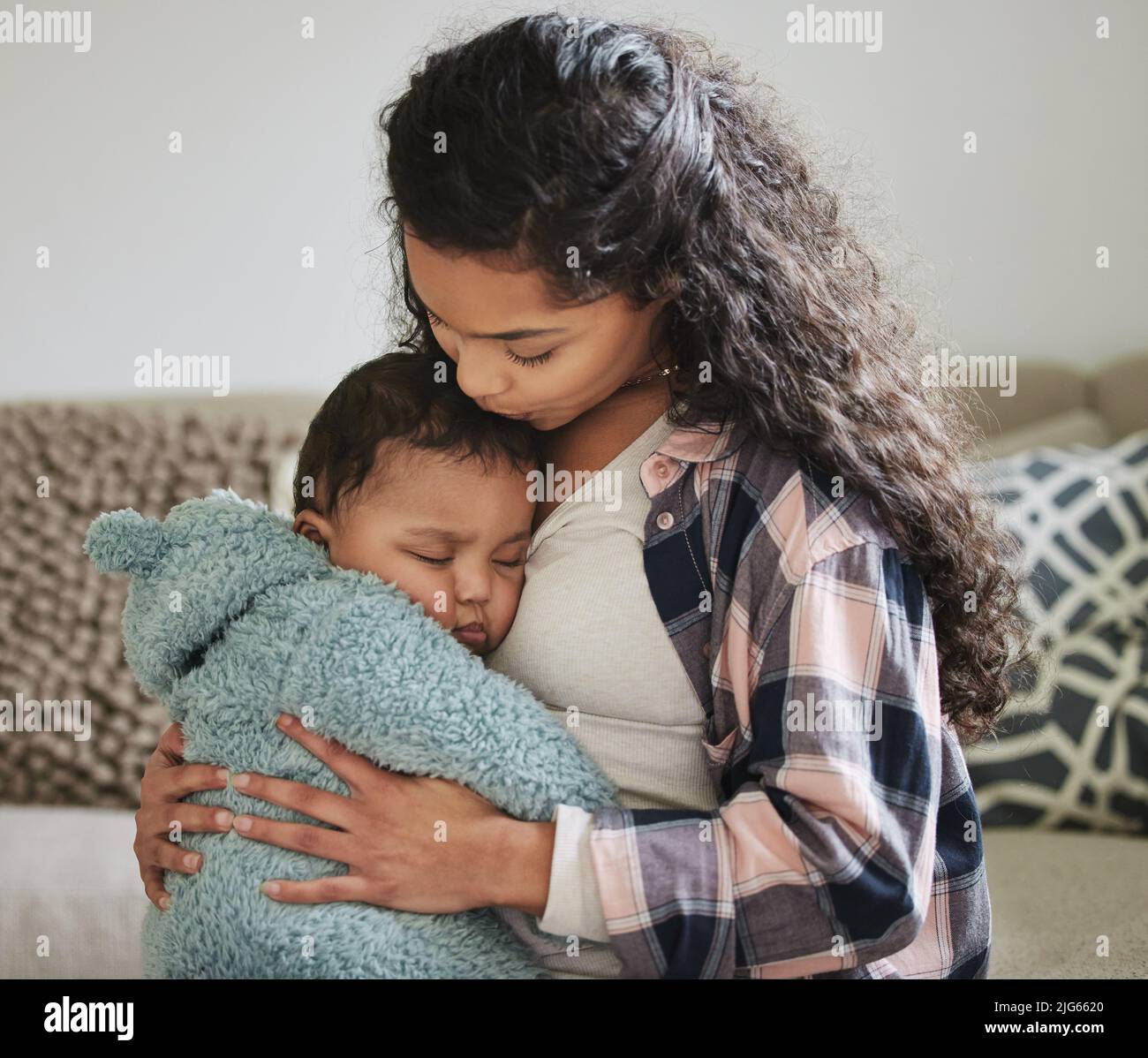 Shes die süßeste. Aufnahme einer jungen Mutter, die ihr Baby zu Hause umarmt. Stockfoto