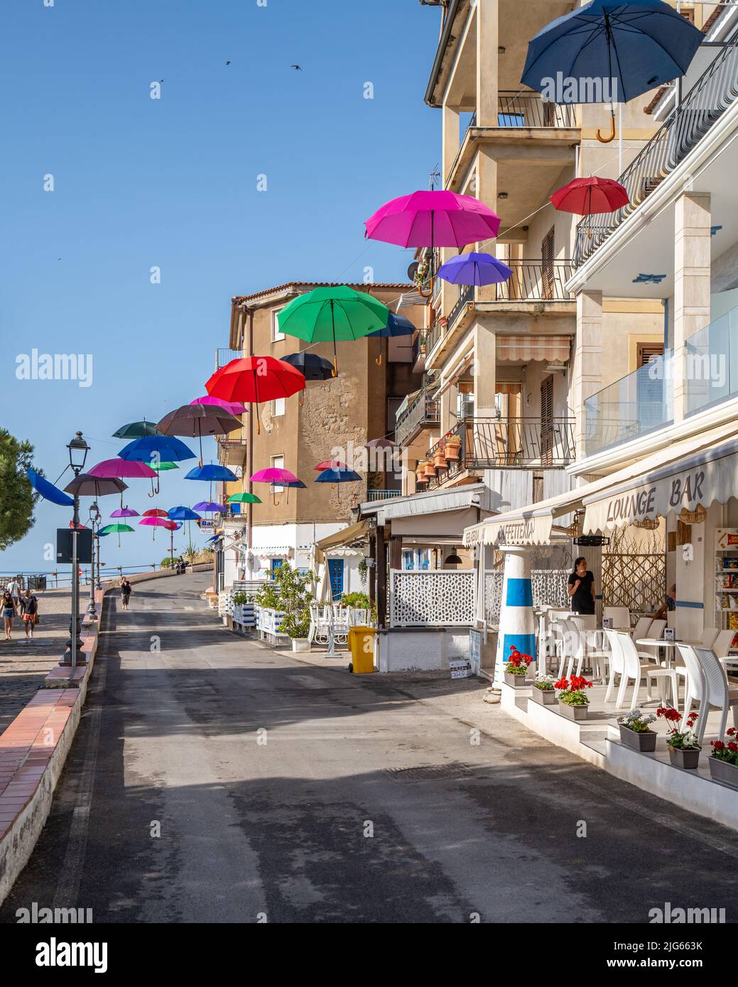 Marina di Camerota, Kampanien, Italien, Juni 2022 - die Uferpromenade von Marina di Camerota mit bunten schwimmenden Sonnenschirmen, ein beliebter Sommertouristenort Stockfoto