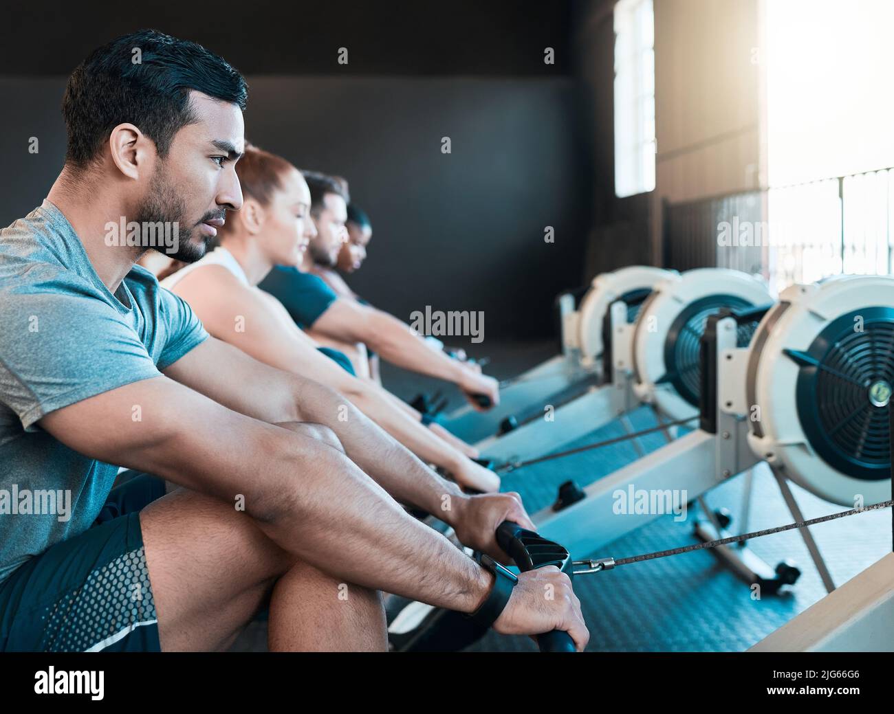Es geht um Ihre Form. Vorstellung einer Gruppe von Menschen, die gemeinsam im Fitnessstudio rudern. Stockfoto