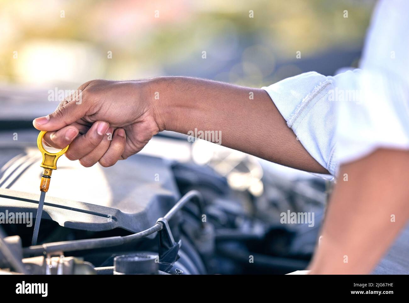 Vielleicht ist es das Öl. Zugeschnittenes Bild eines nicht erkennbaren Mannes, der nach einem Fahrzeugausfall unter der Motorhaube seines Autos nachsehen konnte. Stockfoto