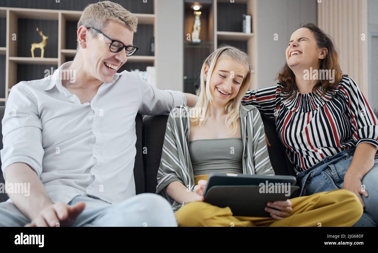 Glückliche kaukasische Familie mit Tablet, Laptop, Telefon zum Spielen von Spielfilmen, Entspannen zu Hause für Technologie Lifestyle-Konzept Stockfoto