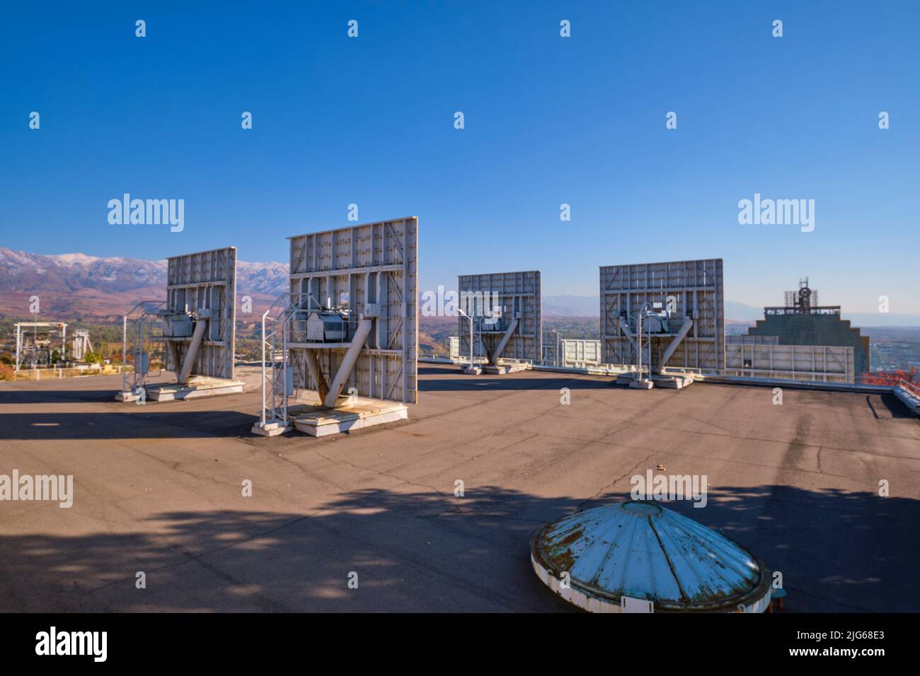 Blick über einige der Spiegelreihen auf den riesigen, gebogenen Konzentrator am Physik-Institut der Sonne für Physik und Technologie. In Parke Stockfoto