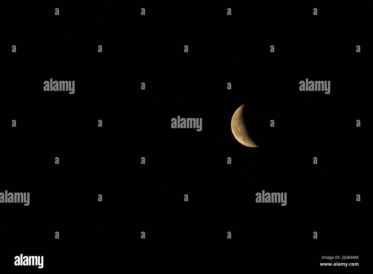 Ein 7-Tage-Phase-Mond in Full HD erscheint im dunklen Himmel der goldene detailreiche Mond am Himmel Stockfoto