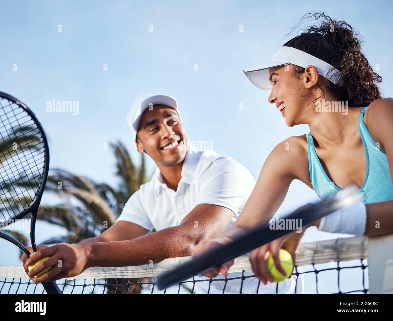 Waren ein starkes Duo. Aufnahme von zwei Tennisspielern, die während des Trainings zusammenstehen und sich auf dem Netz lehnen. Stockfoto