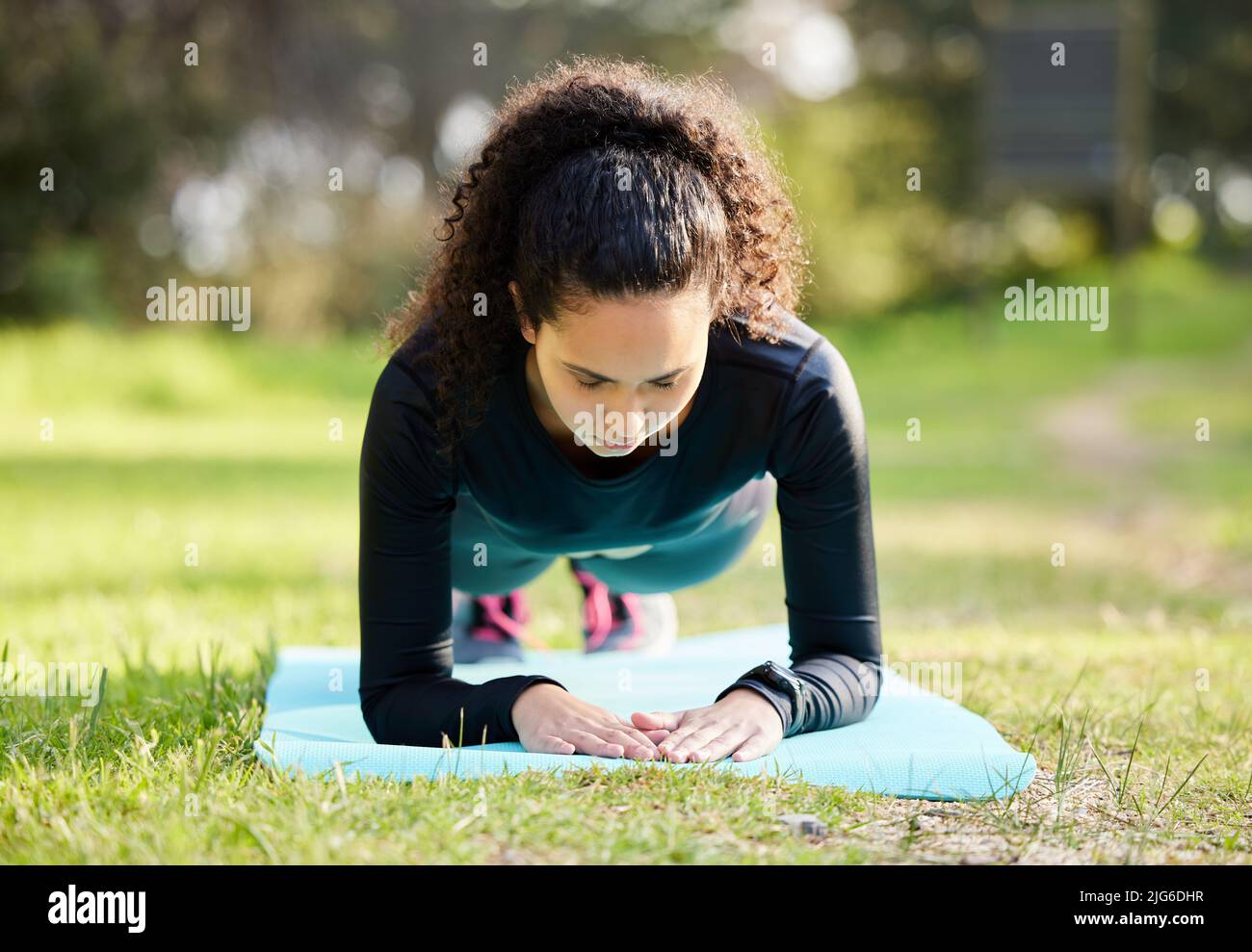 Kanalisieren Sie Ihre innere Stärke. Aufnahme einer jungen Frau, die ihren morgendlichen Yoga draußen genießt. Stockfoto