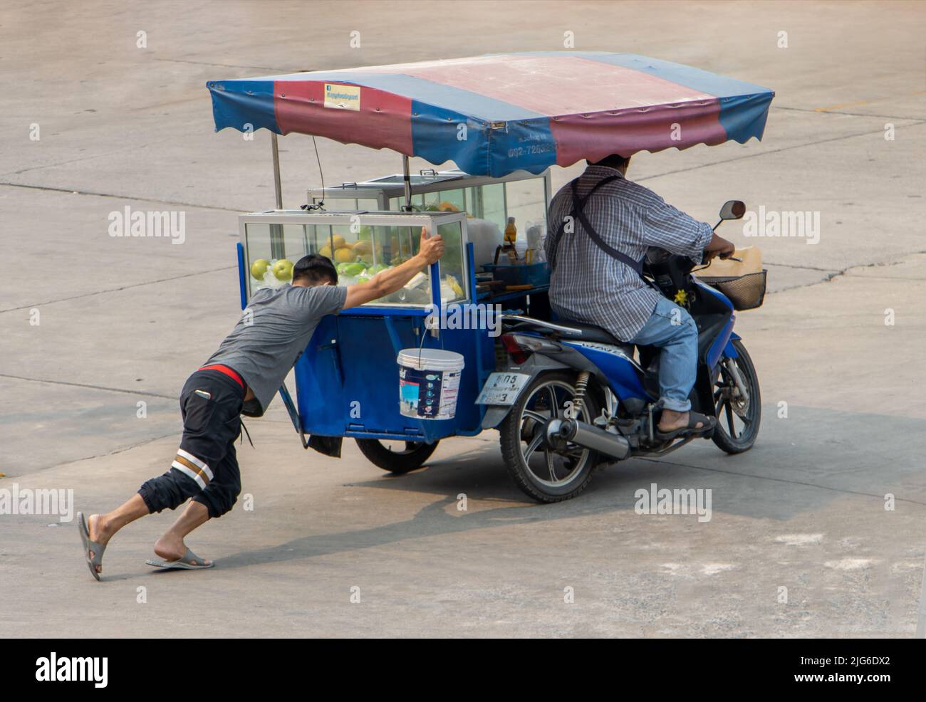 SAMUT PRAKAN, THAILAND, APR 07 2022, Ein Mann schiebt ein Motordreirad mit einem Obstverkäufer Stockfoto