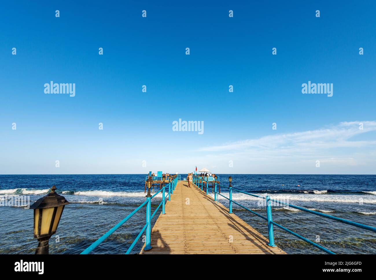 Rotes Meer bei Marsa Alam, Ägypten, Afrika. Hölzerner Pier über dem Korallenriff, der zum Tauchen, Schnorcheln und Schwimmen mit einer Gruppe von Touristen genutzt wird. Stockfoto